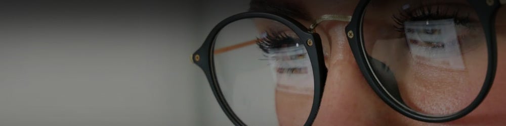 Close up of a man wearing glasses looking at a screen